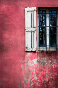 旧的红色粉刷墙上装饰用又脏又臭的窗口