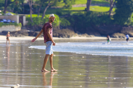 在海滩上戴的帽子的男人