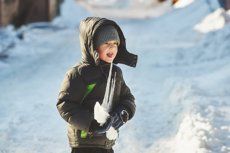 男孩拿着一根冰棍的冬季散步