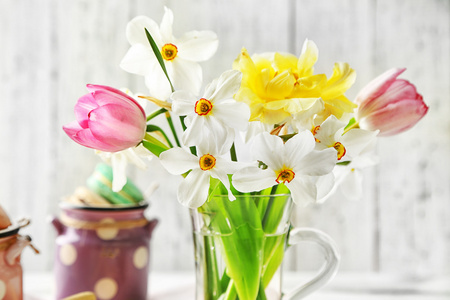 春天鲜花玻璃杯子和美味杏仁色木背景