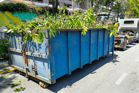 垃圾容器闩锁与园林垃圾树林里满载的卡车