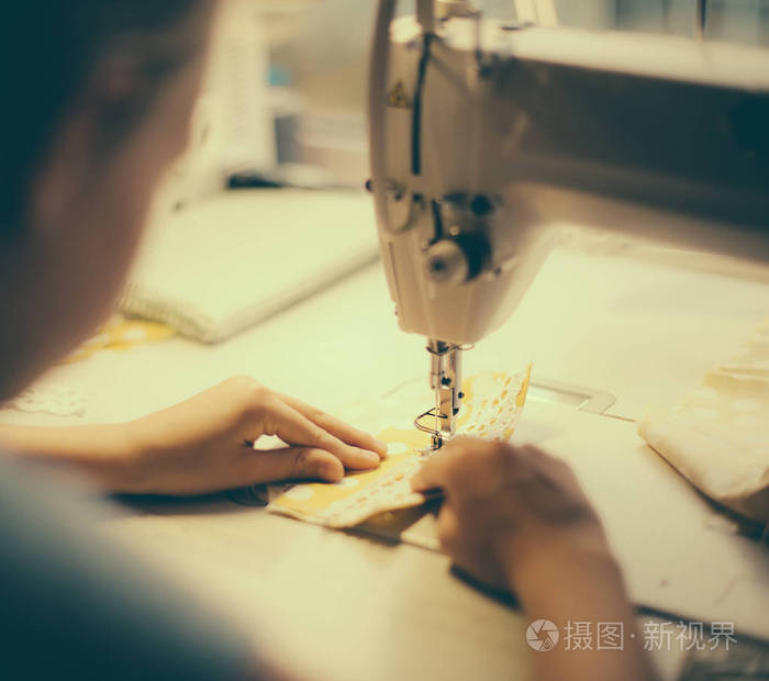 小女孩在缝纫机在家里工作.特写视图