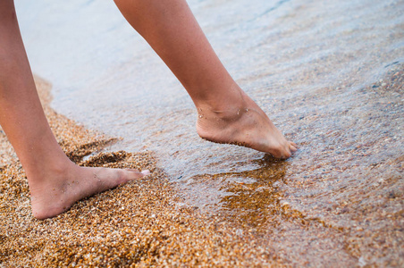 女性的脚在沙滩上。贝加尔湖