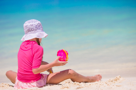 可爱快乐的小女孩，在浅海沙滩玩具