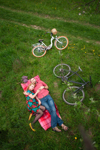 恩爱的小夫妻与自行车在春天的花园