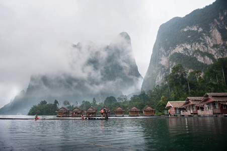 在河里居住的竹漂流小屋清晨满是雾的石灰石山背景