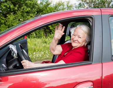 满脸笑容的老妇坐在车里