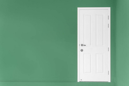 在绿色的墙上在家里封闭白色的门
