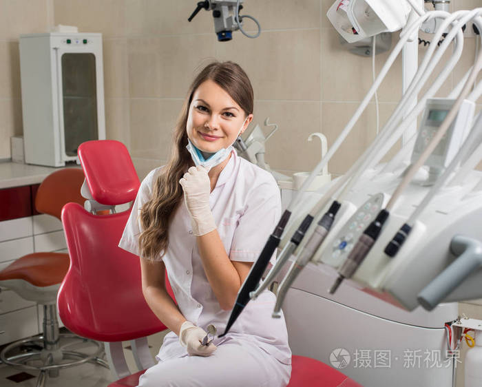 有吸引力的女医生,用显微镜在现代牙医办公室