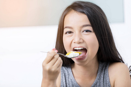 休闲快乐亚洲女孩在家里节食和吃健康的大米