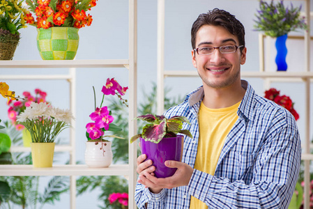 年轻男子在一家花店工作的花店图片