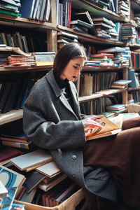 旧的图书馆里的女人阅读本书的肖像
