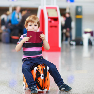 你打算在假期旅行的行李箱在机场的小男孩