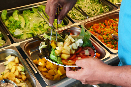 夹紧板在蔬菜和水果沙拉的人。干净的食物和饮食概念。健康的食物