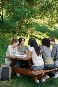 青年学生坐着谈话时在户外学习