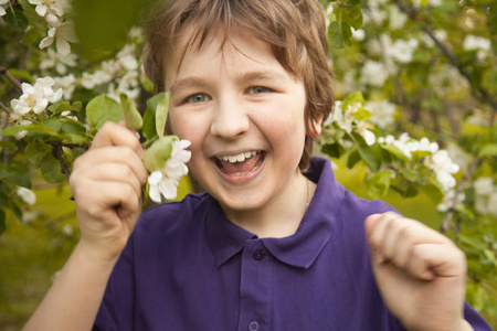 快乐微笑的可爱的孩子男孩在花园里玩