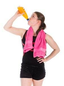 在体育的年轻女子穿喝橙汁。孤立的白色