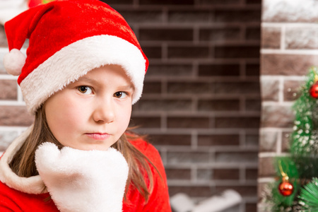 小女孩身穿圣诞老人服装的壁炉。圣诞节和新年