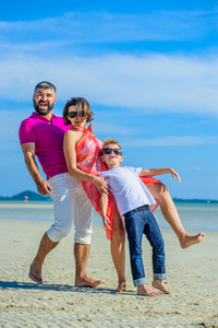 幸福的家庭，三个在热带海滩，笑和责成
