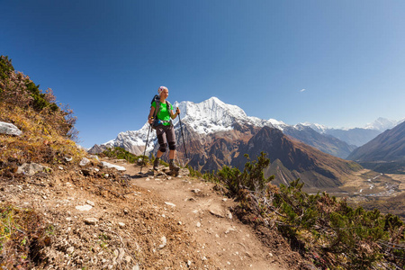 徒步旅行者是 climbig 到在高原上的喜马拉雅山马纳斯卢峰大本营