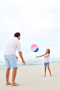 父亲和女儿在海滩上玩