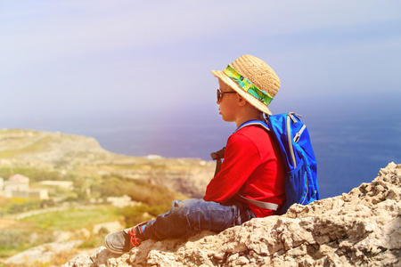 小男孩看着风景的山中徒步旅行图片