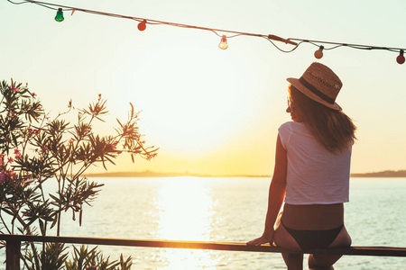 年轻女人享受海边的夕阳