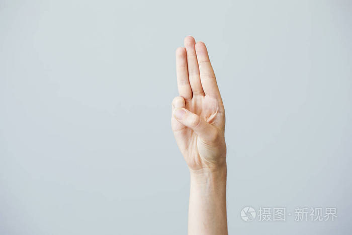 三个手指敬礼在灰色的背景上