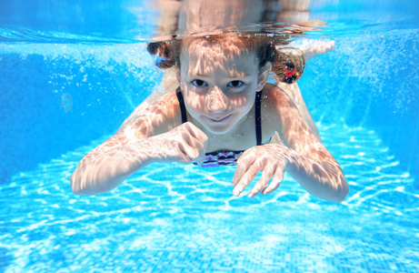 快乐的女孩游在水下，游泳池游泳 踢球和玩乐的好动小孩，儿童水运动