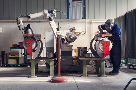 工人准备金属零件焊接机器人的手臂