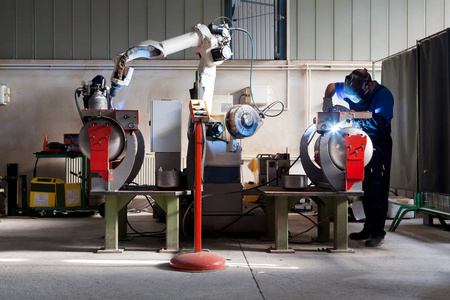 工人准备金属零件焊接机器人的手臂