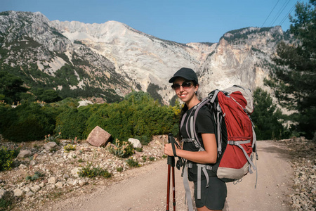 山中徒步旅行。一个女孩站在高山的背景下。那个女孩正在休息