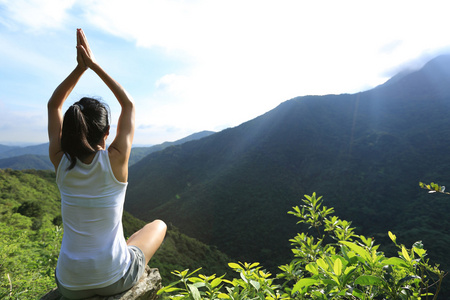 瑜伽女人在山的顶峰