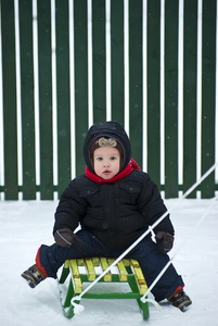 男孩坐在雪橇上