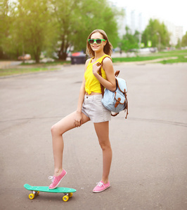 时尚潮人酷女孩在与滑板有 f 太阳镜