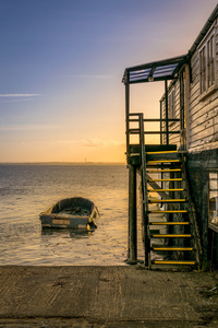 日落时海边的船和木梯