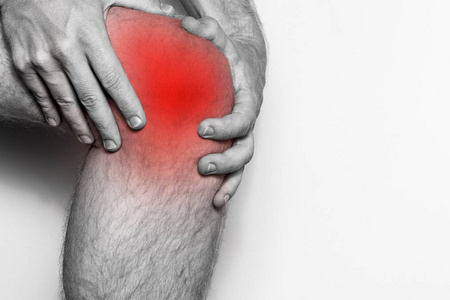 膝盖关节，特写镜头的急性疼痛。单色图像，在白色背景上分离。疼痛的红颜色的区域