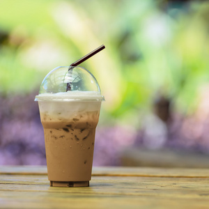 用稻草在塑料杯里的冰的咖啡