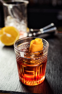 杯威士忌 白兰地或白兰地 与柠檬和冰块站在酒吧柜台上的背景瓶子