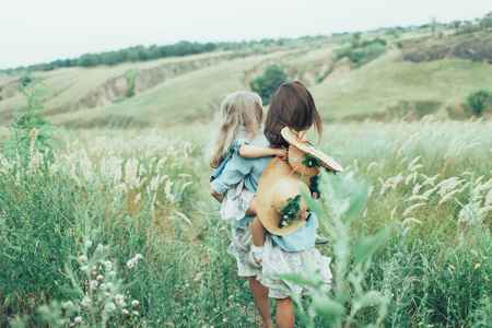 年轻的母亲和女儿上绿草背景