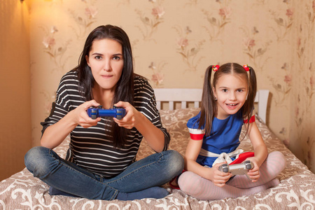 母亲和女儿玩游戏控制台