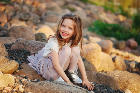 小女孩在玩石头海滩上