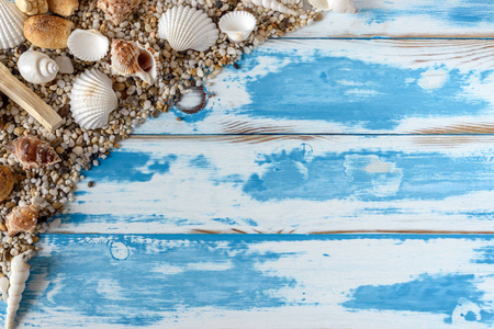在老式的蓝色木板上的海贝壳框架。暑期假期背景