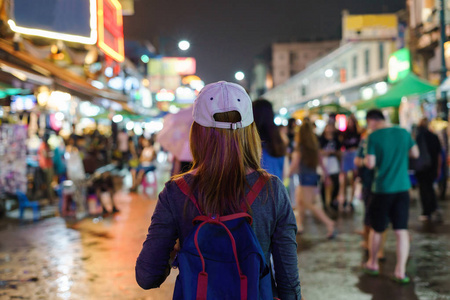 年轻女性旅行者在晚上走在考山路