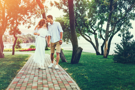 美一对夫妇走在夏天公园接吻。享受生活在一起的概念