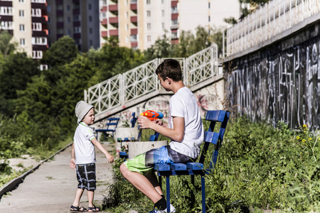 男孩和青少年在街上玩夏天水枪