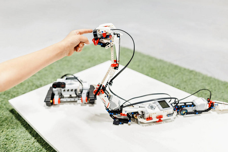 手触摸到一种蛇形机器人组装从设计器 教育和学校的机器人概念