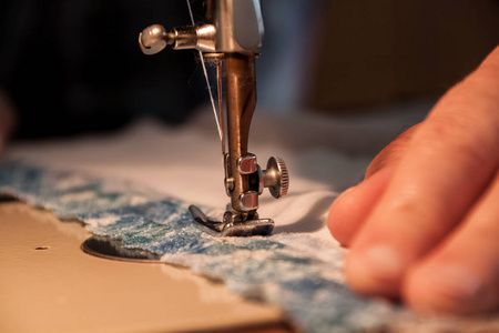 缝纫机，缝制过程中，妇女的手里拿着一块布到