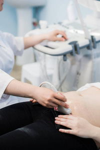 特写镜头的移动超声探头在怀孕的女人胃在医院的医生