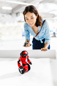 年轻的成年女性，看着展出的玩具机器人